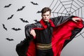 Vampire Halloween Concept - Portrait of handsome caucasian Vampire halloween costume fluttering his red, black cloak. Royalty Free Stock Photo