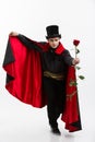 Vampire Halloween Concept - Portrait of handsome caucasian Vampire holding red beautiful rose on white studio background Royalty Free Stock Photo