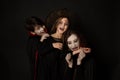 Vampires biting a witch, children in halloween costumes