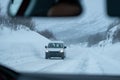 Van driving on highway road with snow covered in blizzard