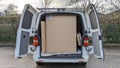 A delivery van filled with large flat cardboard boxes ready to be unloaded