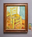 Van Gogh\'s Chair with Pipe. The painting shows a rustic wooden chair with a simple woven straw seat on a