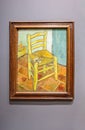 Van Gogh\'s Chair with Pipe. The painting shows a rustic wooden chair with a simple woven straw seat on a