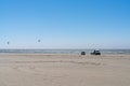 Van life kite surfers parked on a golden beach next to the ocean