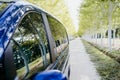 van in the middle of a path of trees, reflection on the window. travel concept