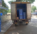 Van parked with crates of Nandini milk beside a food retail shop.