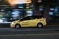 VANCOUVER, BC, CANADA - SEPT 21, 2019: A Vancouver yellow taxi speeding down West Georgia street on a busy Saturday