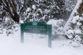 View of sign Board `Ted and Mary Greig Rhododendron Garden` covered in snow in Stanley Park in Vancouver