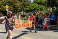 People are walking on Pacific Street with a huge sign Queers Against Climate Genocide during the Pride Parade