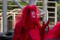 A member of extinction rebellion dressed in red robe walks with palms held up near Burrard Station