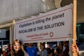 Activist with a sign: CAPITALISM is killing the planet, SOCIALISM is the solution as part of the Global Climate Strike in