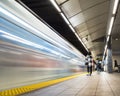 Vancouver City Center station at evening rush hour with trains rushing by and commuters waiting.