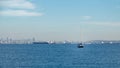 Vancouver skyline with a sailboat and tanker ships on a sunny day.