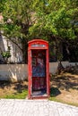 Vandalised red telephone booth on pavement of street