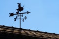 Vane on roof of house outdoor with witch and arrow pointing the direction of the wind