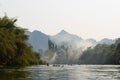 Vang Vieng, Laos - February 16, 2016 : Tourists oar the kayaking among the mountains in Nam song river on February 16, 2016