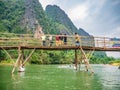 Unacquainted people on the wooden bridge and kayaking at namsong river vangvieng city Laos