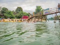 Unacquainted people on the wooden bridge and kayaking at namsong river vangvieng city Laos