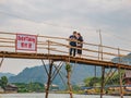 Unacquainted people on the wooden bridge and kayaking at namsong river vangvieng city Laos