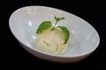 vanilla ice cream scoop with heart of mint leaf in a bowl, with black background Royalty Free Stock Photo