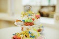 Vanilla bean mini cupcakes decorated with cyan and pink candy beads on a clear tiered tray on a dessert table.Sweet Royalty Free Stock Photo