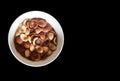 Vanilla and chocolate cornflakes dipped in chocolate milk in a white bowl in black background Royalty Free Stock Photo