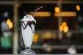 Vanilla chocolate milkshake on a cafe bar with beautiful bokeh of street lamps