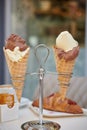 Vanilla and chocolate mixed Ice cream waffle sugar cones in metal holder on the table croissant sugar holder and sugar