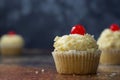 Vanilla cupcake with butter cream and cherry on top. Blue background. Celebrating, sweet food