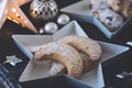 Vanilla-flavored crescent cookies on a white star plate on dark wooden tray