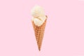 Vanilla ice cream cone on pink faded pastel color background.