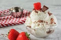 Vanilla ice cream decorated with strawberries and chocolate chips. Delicious frozen dessert. Cooling summer snack.