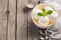 Vanilla ice cream with mint leaves in white bowl on rustic wooden background Royalty Free Stock Photo