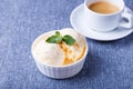 Vanilla ice cream with mint in a white plate and a cup of espresso on a blue background. Homemade ice cream. Close-up Royalty Free Stock Photo
