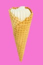 Vanilla ice cream in waffle cone isolated on bright pink and Lee crimson background, vertical close-up frame Royalty Free Stock Photo