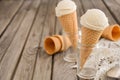 Vanilla ice cream in waffle cone on rustic wooden background Royalty Free Stock Photo