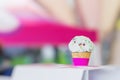 Vanilla ice cream in waffle cone topped with colorful sprinkles, bright blurry background. Selective focus. Copy space