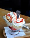 Vanilla ice cream and whipped cream with hot strawberries on a glass bowl. Royalty Free Stock Photo