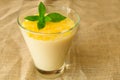 Vanilla mousse or pudding with lemon zest and mint in a glass tall glass. Close-up
