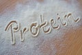Vanilla protein powder - text `protein` in powder on brown board Royalty Free Stock Photo