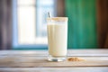 vanilla shake in a frosty glass with a drip down the side on a wood surface Royalty Free Stock Photo