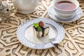 Vanilla souffle with dark chocolate glaze and cup of tea on orientabl wooden table Royalty Free Stock Photo