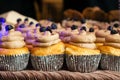 Vanilla wedding cupcakes with cream frosting in foil cups during a catered event