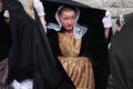 Breton woman in traditional costume hiding from the rain