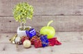 Vantage look Christmas decorations with red ball,green ball,red ribbon,bell,small tree on white pot, and artificial flower. aged a