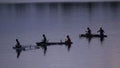 SILHOUETTE: Local people of Vanuatu sit in small boats and throw fishing nets. Royalty Free Stock Photo