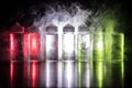 Vape concept. Smoke clouds and vape liquid bottles on dark background. Light effects