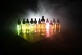 Smoke clouds and vape liquid bottles on dark background. Light effects. Useful as background or vape advertisement or vape Royalty Free Stock Photo