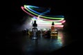 Smoke clouds and vape liquid bottles on dark background. Light effects. Useful as background or vape advertisement or vape Royalty Free Stock Photo