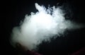 Vaping man holding a mod. A cloud of vapor. Black background. Vaping an electronic cigarette with a lot of smoke Royalty Free Stock Photo